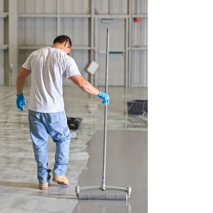 Installer applying epoxy coating to concrete floor