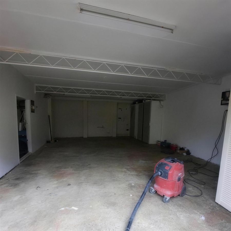 The same garage part-way through preparation, bare slab with a dust extractor on the floor