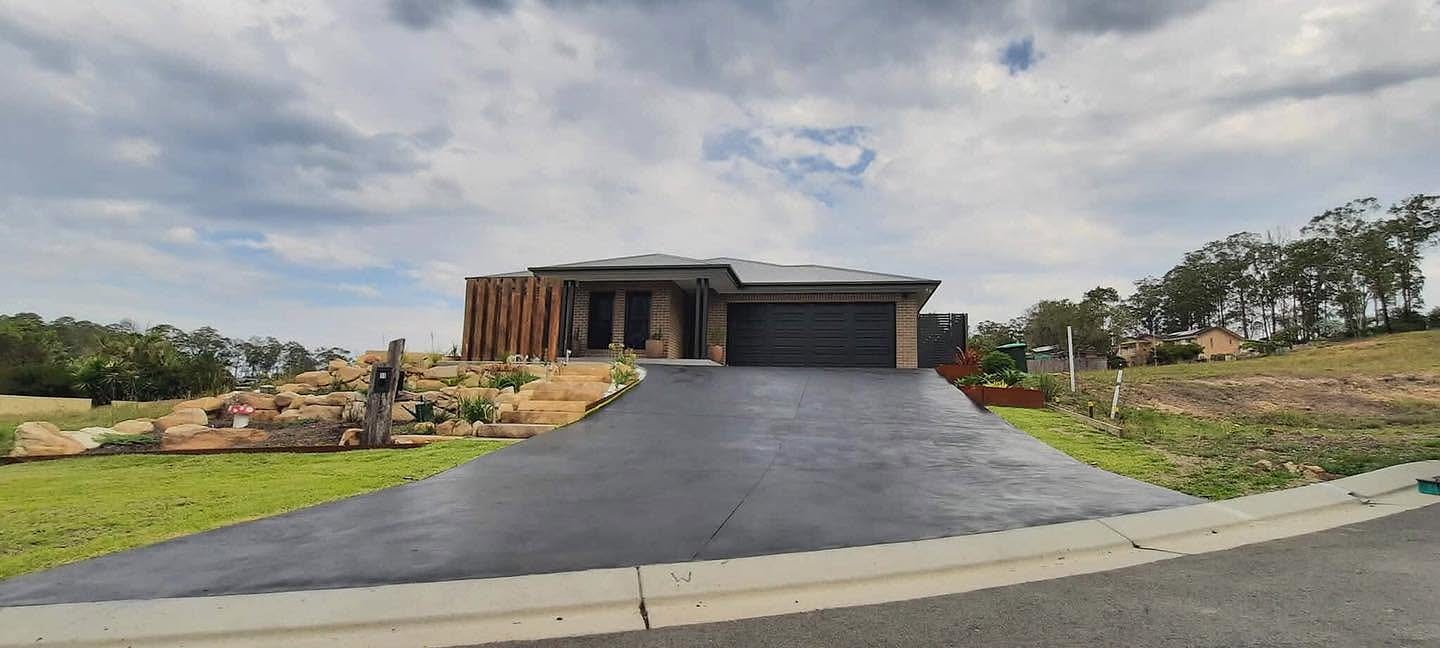 Sealed concrete driveway running up to a modern Australian home