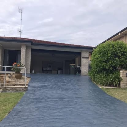 Wide coated driveway leading to a double garage